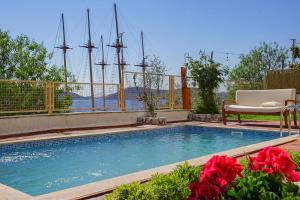 a swimming pool with a chair and some ships in the background at 7 Oda Söğüt in Marmaris
