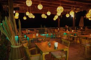 restauracja z drewnianymi stołami, krzesłami i światłami w obiekcie 7 Oda Söğüt w mieście Marmaris