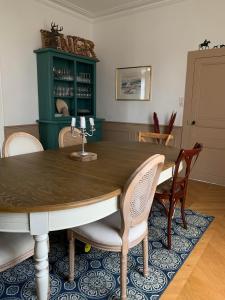 ein Esszimmer mit einem Holztisch und Stühlen in der Unterkunft Maison bourgeoise in Fillé