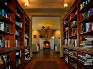 une bibliothèque remplie de livres et une cheminée dans l'établissement La Villa del Valle, à Valle de Guadalupe