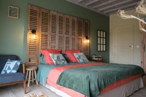 een slaapkamer met een groot bed met een houten hoofdeinde bij Les Galapons in Trept