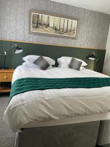 a large bed with a green and white comforter at Black Bull Hotel in Lancaster