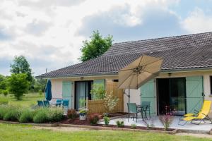 een huis met een patio en een parasol bij Les Galapons in Trept