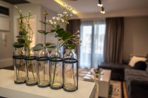a group of glass vases with flowers in them on a table at Apartment Leona in Kraljevo