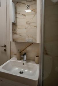 a white sink in a bathroom with a mirror at Apartment Leona in Kraljevo