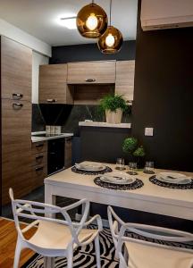 a kitchen with a table and two chairs and a counter at Apartment Leona in Kraljevo