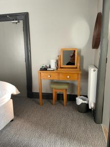 a bedroom with a desk with a mirror and a chair at Black Bull Hotel in Lancaster