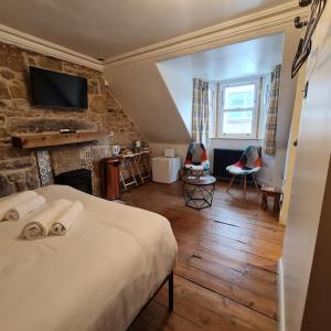 a bedroom with a bed and a tv on the wall at Ness City Cottage in Inverness