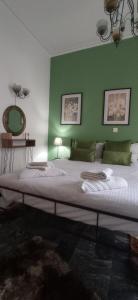 a bedroom with a large bed with a green wall at Nancy Studios in Skala Kallonis