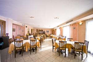 ein Restaurant mit Tischen und Stühlen mit gelben Tischdecken in der Unterkunft Hotel Il Canneto in Porto Ceresio