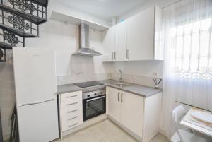 a white kitchen with a sink and a refrigerator at Soul Home Alhaurín el Grande in Alhaurín el Grande