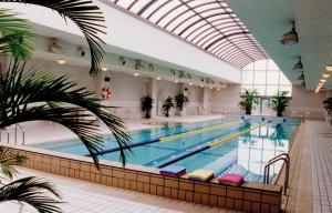 a large swimming pool in a large building at Okura Garden Hotel Shanghai in Shanghai