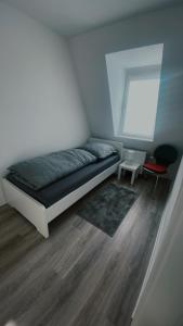 a small bedroom with a bed and a chair at 2 Zimmer,Apartment,Monteur,Netflix,Prima in Krefeld