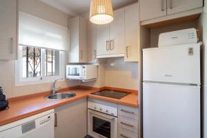 eine Küche mit einem weißen Kühlschrank und einer Spüle in der Unterkunft Almijara Apartments Casasol in Nerja
