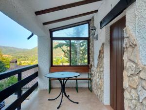- une table sur le balcon d'une maison avec fenêtre dans l'établissement Cabaña 2 Ventorrillo, à Riópar