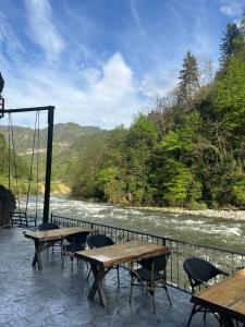 a patio with tables and chairs next to a river at VALLEY SUiT OTEL in Rize
