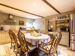 a kitchen with a table and chairs and a refrigerator at Pippinwell in Bakewell