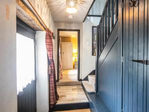 a hallway with blue wood doors and a hallway with a stair at Pippinwell in Bakewell