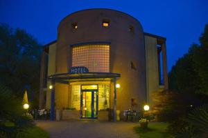 a large building with a lit up door at night at Hotel Il Canneto in Porto Ceresio