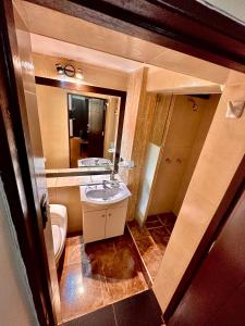 een badkamer met een wastafel, een toilet en een spiegel bij Mama's House in Cuzco