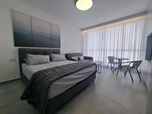 una camera con letto, tavolo e sedie di חוויה בכיכר a Netanya