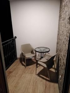 duas cadeiras e uma mesa num quarto em Šarm studio 301 em Zlatibor