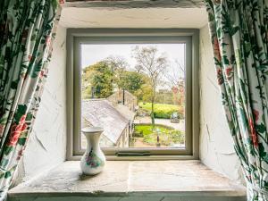 a vase sitting on a window sill with a view at Cuckoo in Bakewell