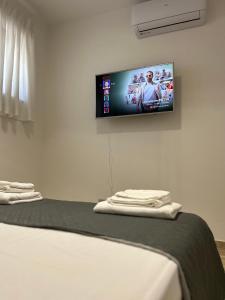 a room with a tv on a wall with a bed at NEWHOUSE ROOFTOP in Nettuno