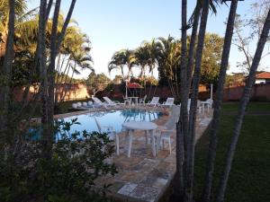 d'une terrasse avec une table et des chaises à côté de la piscine. dans l'établissement Giardino Mediterraneo, à São Pedro