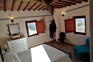 ConfigniにあるCasale dei 3 galliのベッドルーム1室(ベッド1台、鏡、窓付)