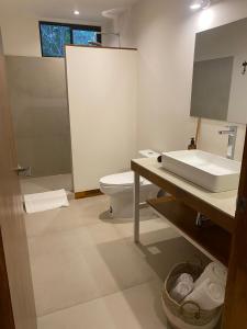 a bathroom with a white toilet and a sink at Villa Laia - Santa Teresa in Santa Teresa Beach