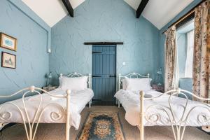 two beds in a room with blue walls at Slipper Lo in Bakewell