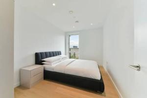 um quarto branco com uma cama e uma janela em Stunning Zone 1 Luxury Brand New 2 Bed Apartment em Londres