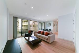 uma sala de estar com um sofá e uma mesa em Stunning Zone 1 Luxury Brand New 2 Bed Apartment em Londres