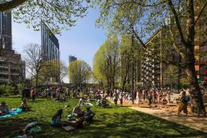 a crowd of people sitting on the grass in a park at Stunning Zone 1 Luxury Brand New 2 Bed Apartment in London