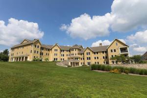 um grande edifício com um campo relvado à sua frente em Jackson Gore Village on Okemo Mountain em Ludlow