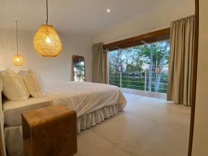 a bedroom with a bed and a large window at Villa Laia - Santa Teresa in Santa Teresa Beach