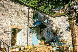 a stone house with a blue door and a table and chairs at Fruitpip in Bakewell