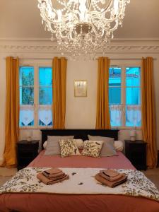 um quarto com uma cama grande e um lustre em Clos Montcenoux, au coeur de Bourges. em Bourges
