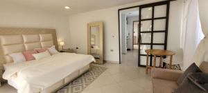 1 dormitorio con 1 cama blanca grande con almohadas rosas en Casa Suite Palmar del viento FRENTE, FRENTE AL MAR, en Moñitos