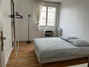 a white bedroom with a bed and a window at Appartement T5 standing 104m2 in Orléans