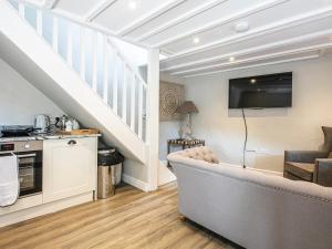 a living room with a couch and a staircase at The Artists Loft in Bakewell