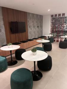 uma sala de conferências com mesas e cadeiras e uma televisão em loft luxuoso Home & Lifestyle Ibirapuera. N.946 em São Paulo