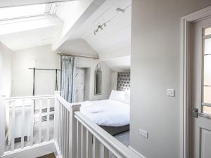 a white room with a bed and a window at The Artists Loft in Bakewell
