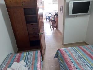 Habitación con cama, TV y cocina. en Apartamento central melgar, en Melgar