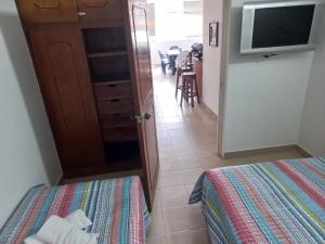 une chambre avec un lit et une télévision et une cuisine dans l'établissement Apartamento central melgar, à Melgar