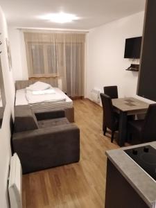 een kamer met een bed, een tafel en een keuken bij Šarm 402 in Zlatibor