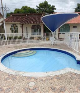 une petite piscine avec un parasol bleu devant une maison dans l'établissement Apartamento central melgar, à Melgar 1 autre photo