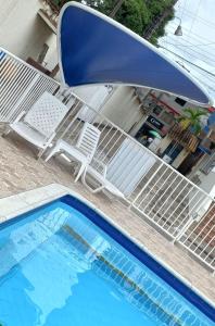 - Piscina con tumbona, silla, mesa y piscina en Apartamento central melgar, en Melgar
