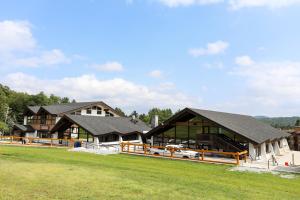 a large building with a grass field in front of it at Mountain Lodge at Okemo in Ludlow